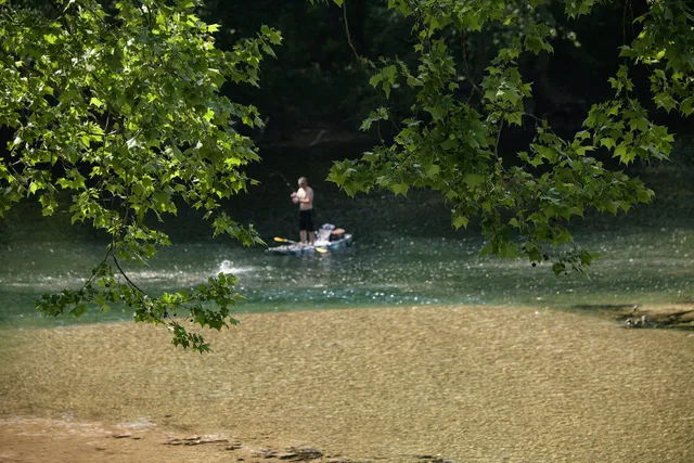 A fisherman with a standup paddleboard on the Elk River, in West Virginia, on May 25, 2023. The 73-mile Elk River trail winds through Braxton and Clay County, and the 102-mile Elk River Water Trail flows from Sutton to Charleston, WV. These trails are included in the Pioneer Trail Network that conne. A weighted rubric for scoring travel creators